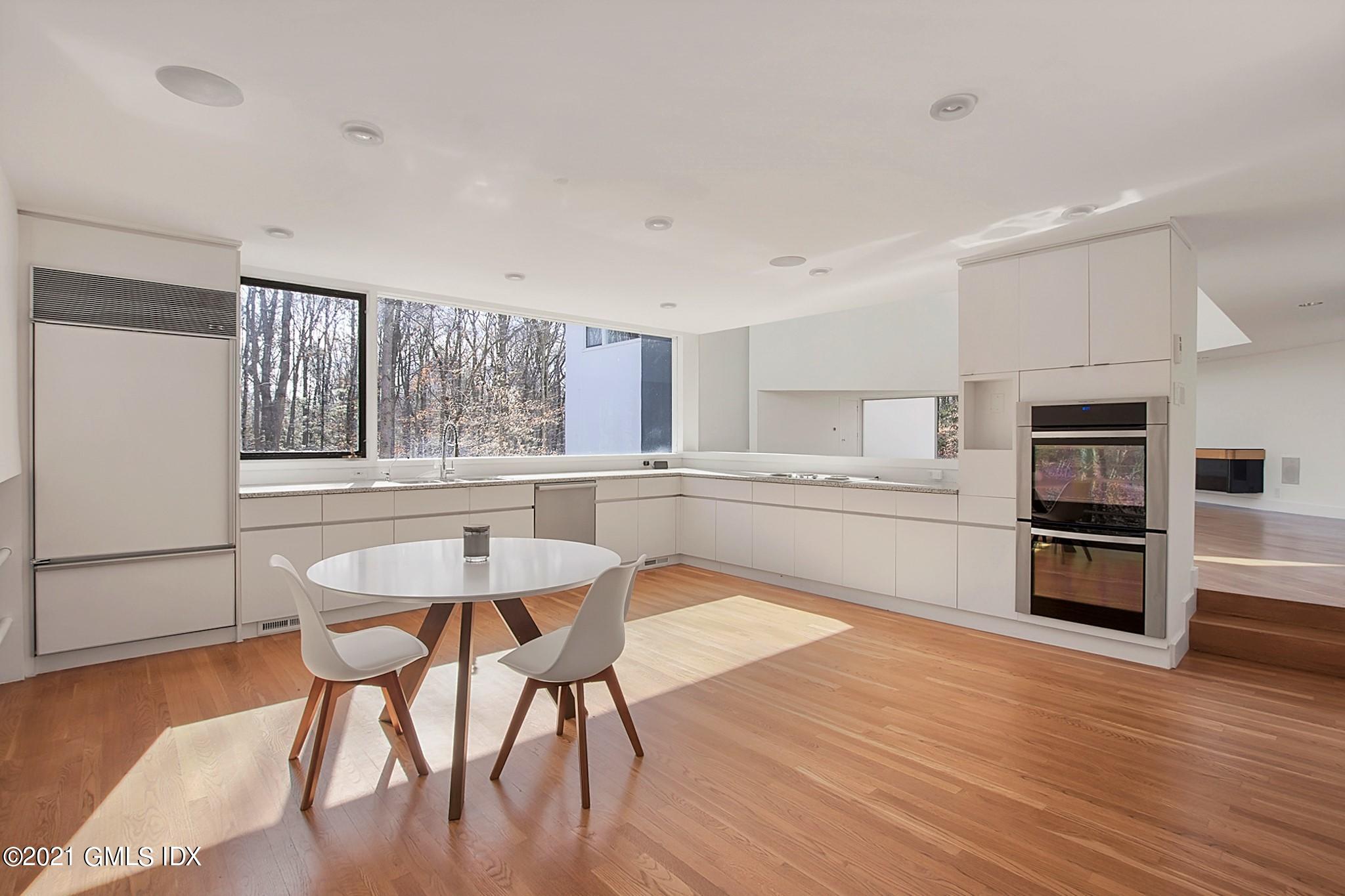 15 Hycliff Road Greenwich, CT 06831 - Photo 6 of 27 a kitchen with stainless steel appliances kitchen island wooden floors and white cabinets