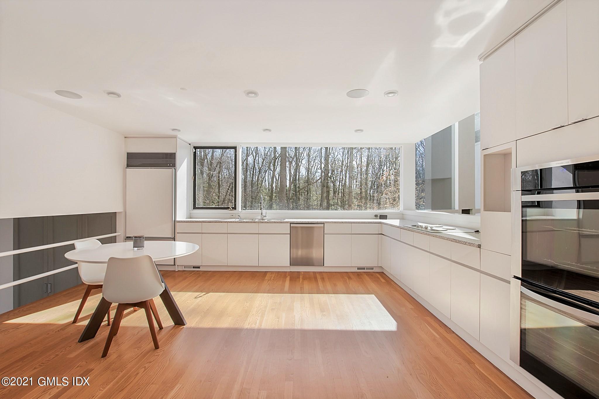 15 Hycliff Road Greenwich, CT 06831 - Photo 7 of 27 a large white kitchen with wooden floor and a large window