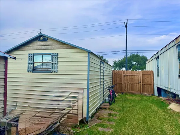 a view of a house with a small yard and wooden fence
