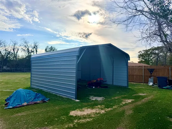 a view of a backyard with potted plants and a large tree
