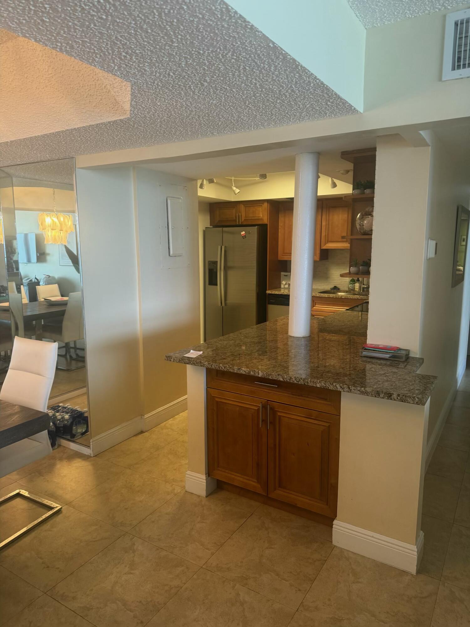 3610 South Ocean Boulevard, Unit 610 South Palm Beach, FL 33480 - Photo 3 of 14 a kitchen with granite countertop a sink and a refrigerator
