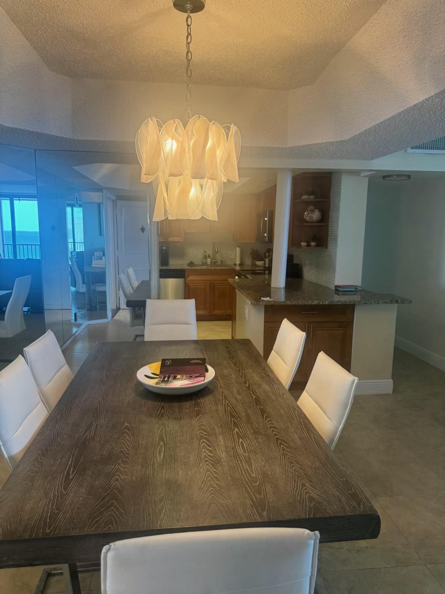 3610 South Ocean Boulevard, Unit 610 South Palm Beach, FL 33480 - Photo 4 of 14 a living room with dining table and a chandelier