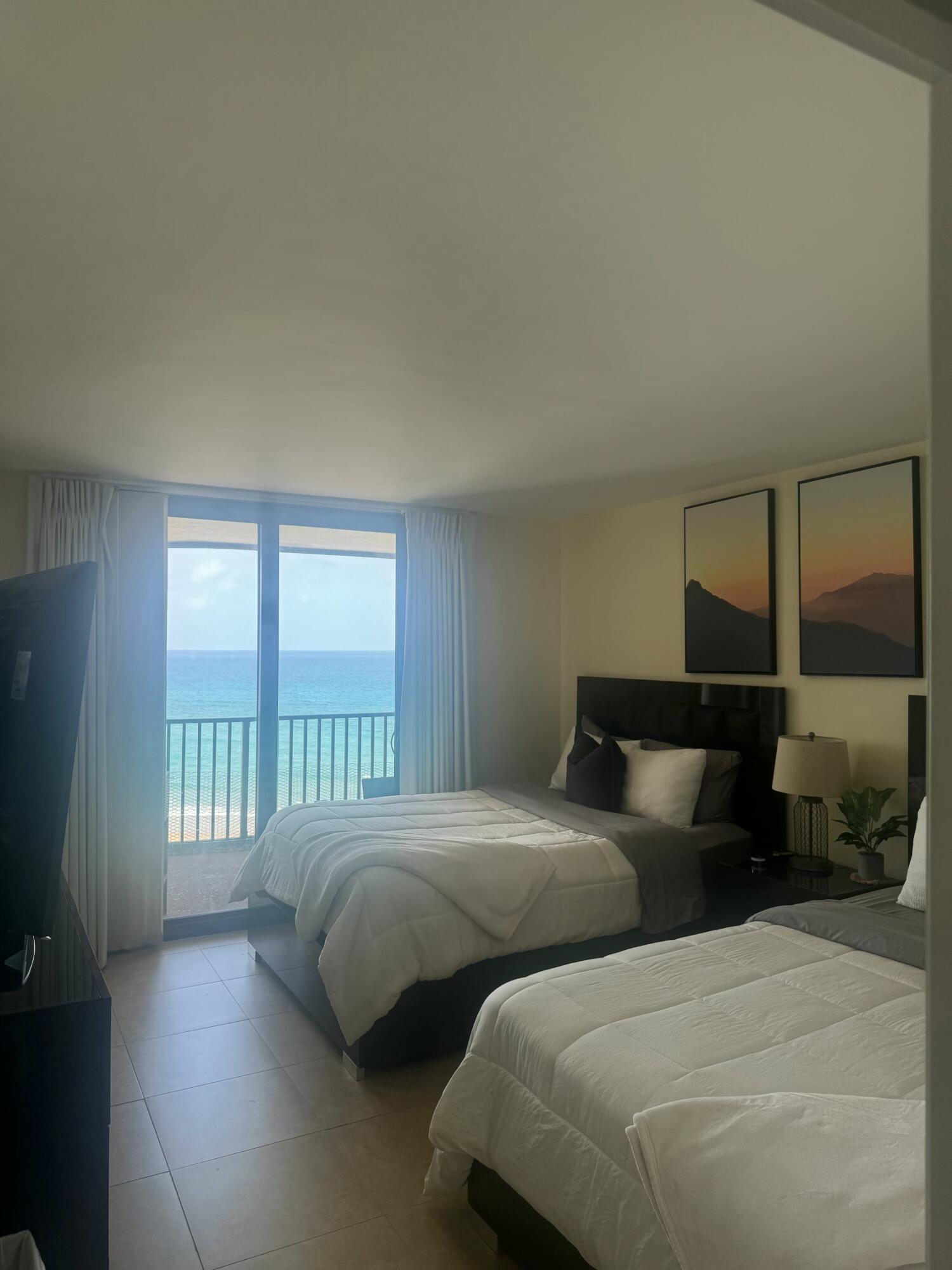 3610 South Ocean Boulevard, Unit 610 South Palm Beach, FL 33480 - Photo 8 of 14 a bedroom with two beds and a large window