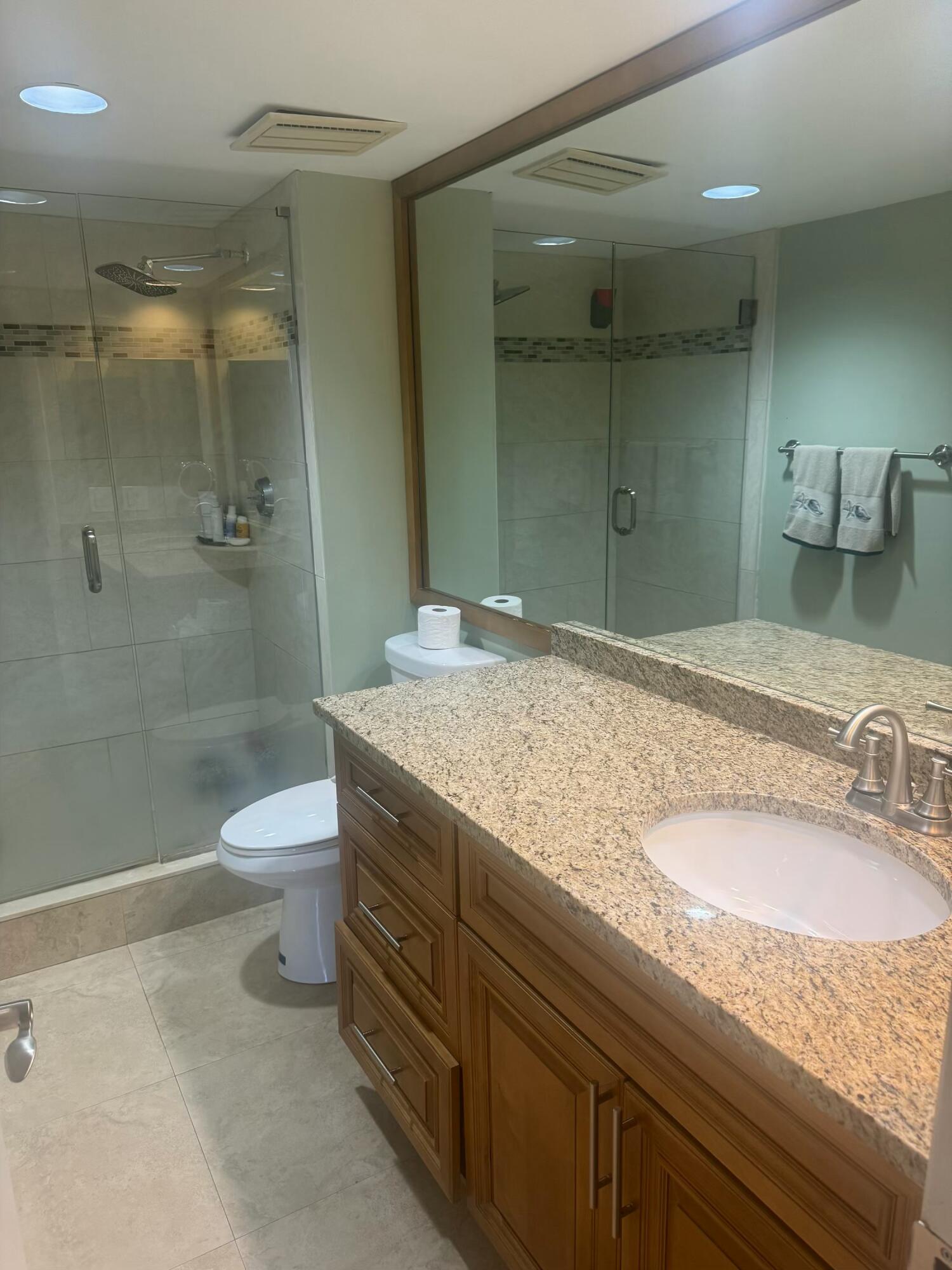 3610 South Ocean Boulevard, Unit 610 South Palm Beach, FL 33480 - Photo 9 of 14 a bathroom with a granite countertop sink a toilet and shower