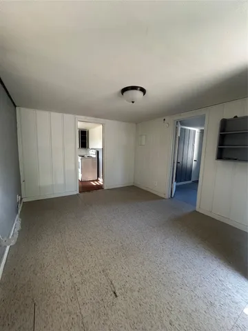a view of a livingroom with an empty space and a window