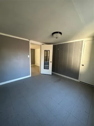 an empty room with a fireplace and windows