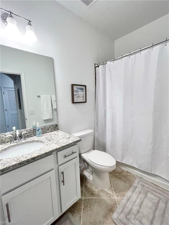 43020 Greenway Boulevard, Unit 345 Babcock Ranch, FL 33982 - Photo 14 of 42 a bathroom with a granite countertop sink a toilet and a mirror