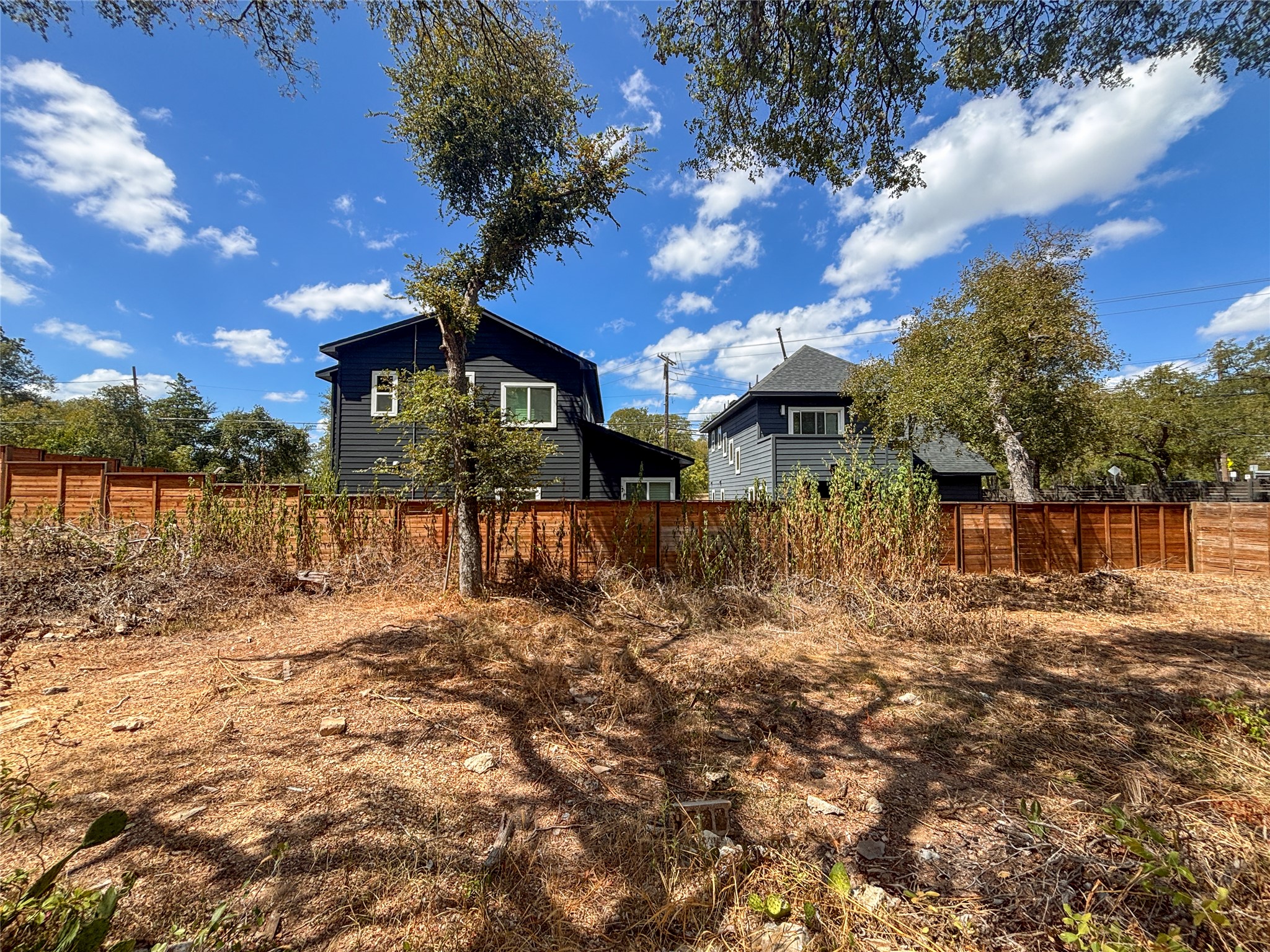 4602 Santa Anna Street Austin, TX 78721 - Photo 10 of 14 Mature trees shade a spacious back lot bounded by a solid wood fence line.