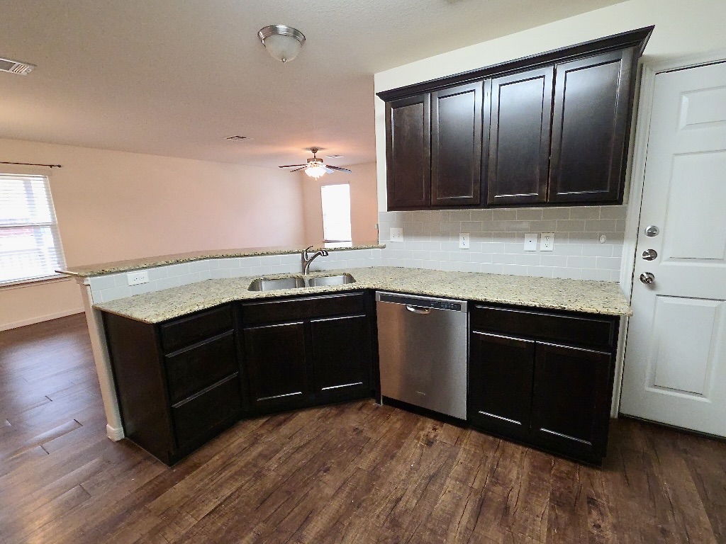 306 Wyeth Street Taylor, TX 76574 - Photo 6 of 20 Kitchen with dark wood cabinetry and stainless steel appliances.