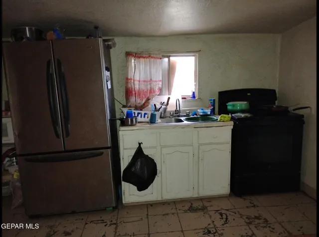a kitchen with a refrigerator and a stove