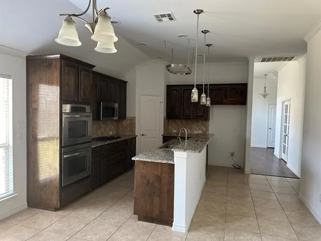 a kitchen with a sink stainless steel appliances and cabinets