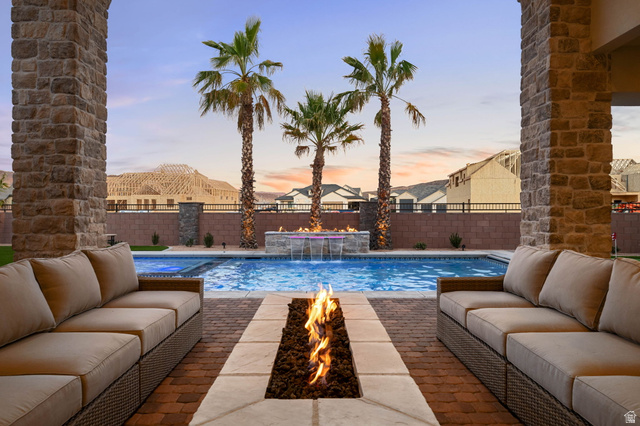 4871 South Homestead Way Washington, UT 84780 - Photo 109 of 151 View of pool featuring an outdoor living space with a fire pit, patio surround, and a fenced backyard