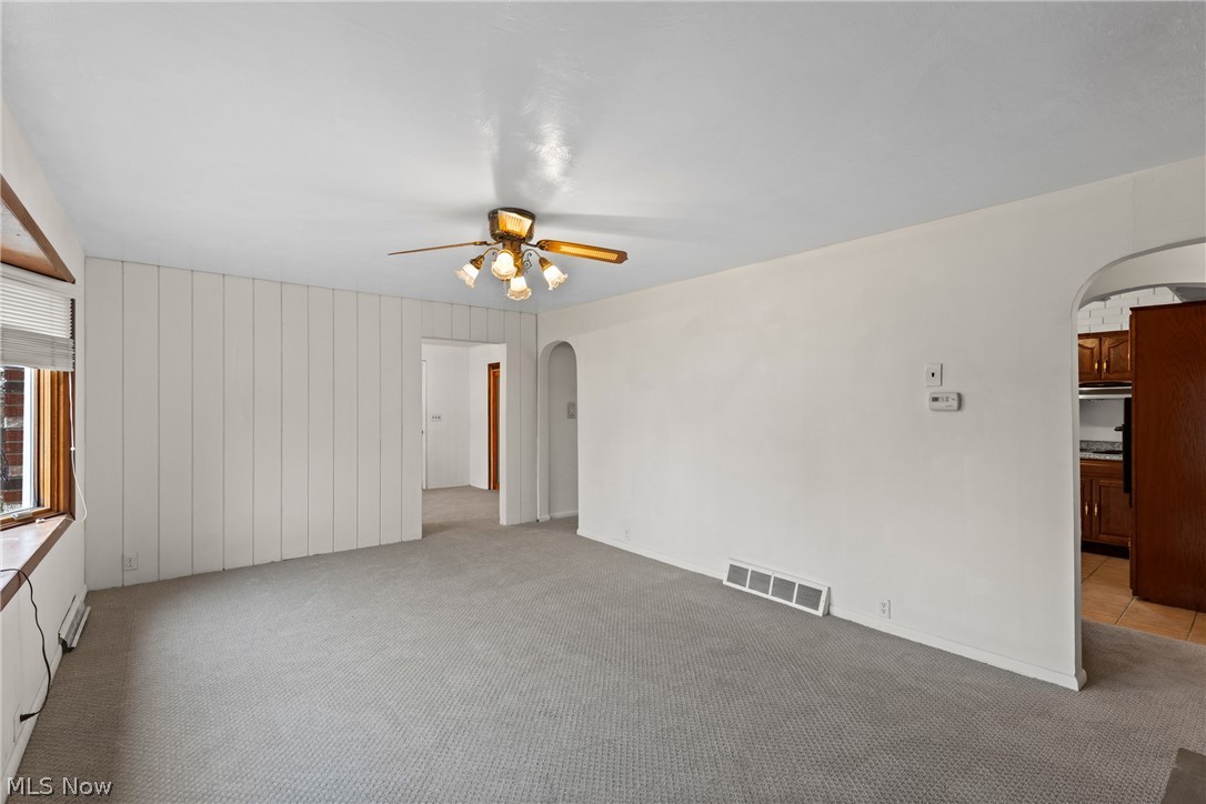 70828 Crescent Road St. Clairsville, OH 43950 - Photo 6 of 40 Empty room with arched walkways, light carpet, a ceiling fan, and a baseboard heating unit