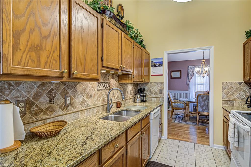 7503 Bartonshire Court Oak Ridge, NC 27310 - Photo 8 of 24 Granite countertops and tiled backsplash in the Kitchen.