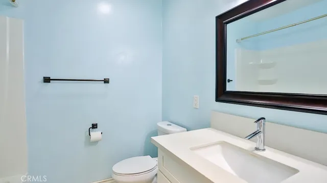 a bathroom with a sink vanity mirror and toilet
