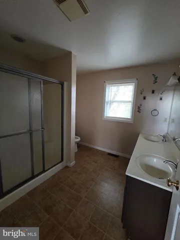 an empty room with windows and fireplace