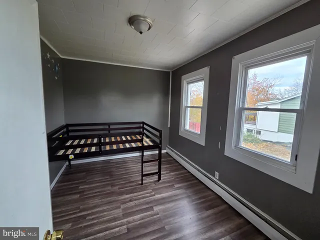 a view of a room with wooden floor and windows