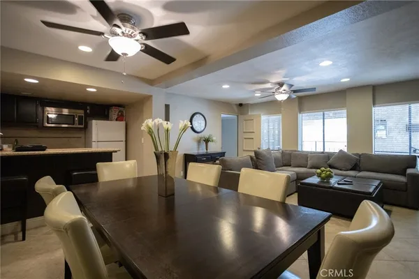 a living room with furniture kitchen view and a large window