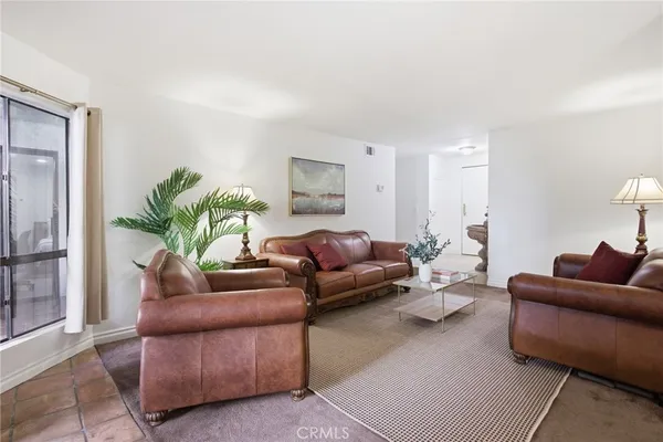 a living room with furniture and a potted plant