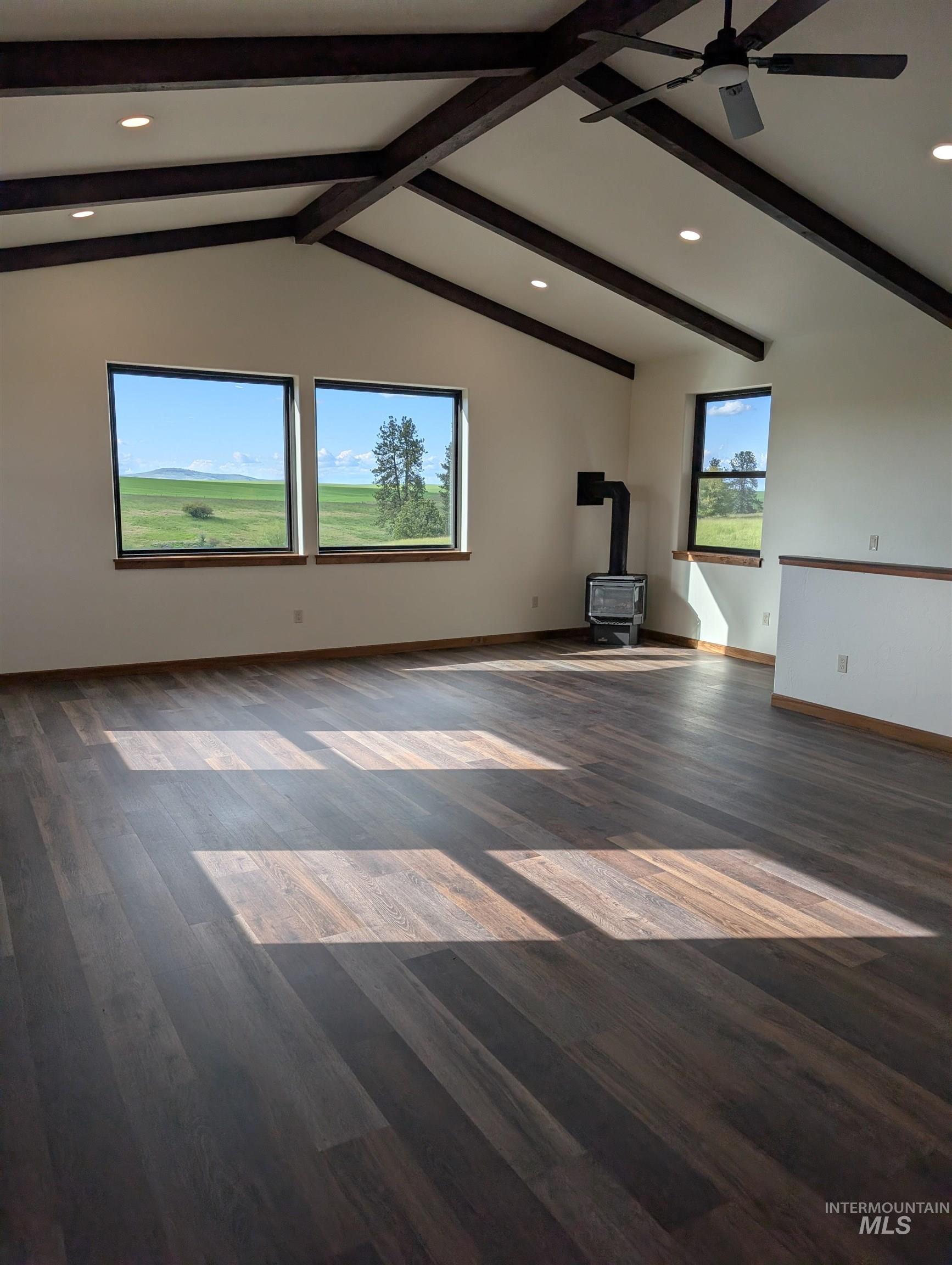 137 Angus Ranch Grangeville, ID 83530 - Photo 13 of 49 Unfurnished living room featuring a wood stove, recessed lighting, beamed ceiling, and dark wood-style floors