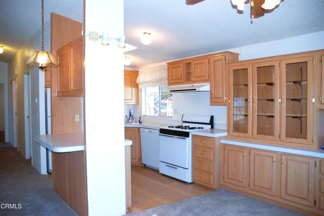 a kitchen with granite countertop a stove a sink and a refrigerator