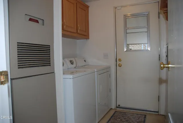 a utility room with cabinets washer and dryer