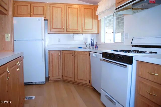a kitchen with stainless steel appliances granite countertop a refrigerator stove and sink