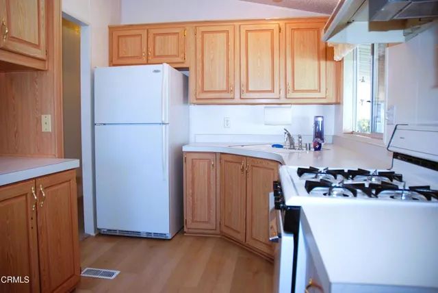 a kitchen with a refrigerator sink stove and cabinets