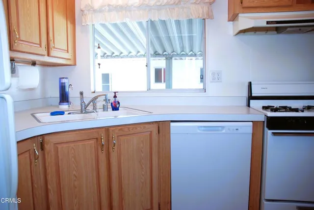 a kitchen with stainless steel appliances a sink stove and cabinets
