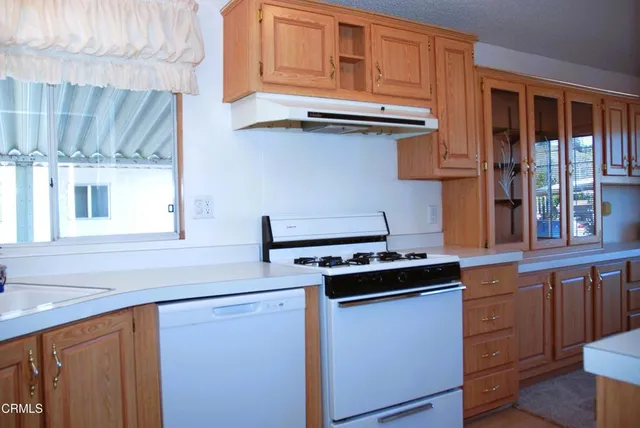 a kitchen with stainless steel appliances granite countertop a sink stove and cabinets