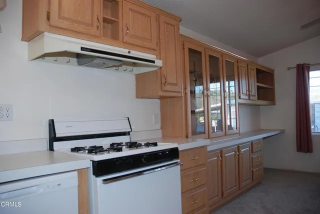 a kitchen with stainless steel appliances granite countertop a sink stove and cabinets