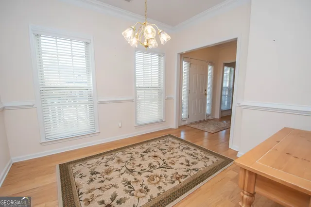 a view of a bedroom with wooden floor and a rug