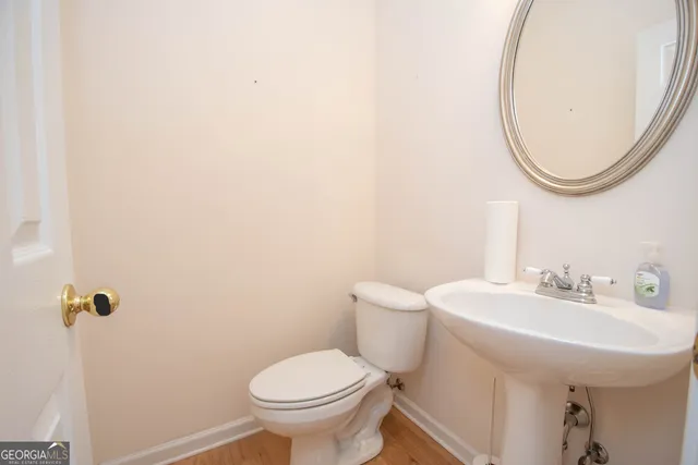 a bathroom with a sink a toilet and a mirror