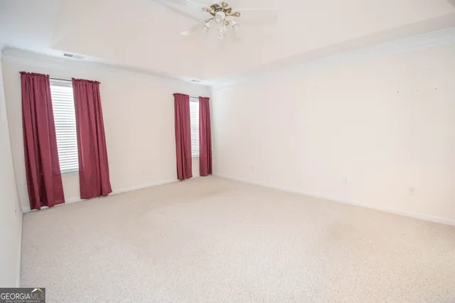 a view of a room with a chandelier fan and a window
