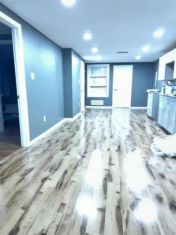 a view of empty room with kitchen and window