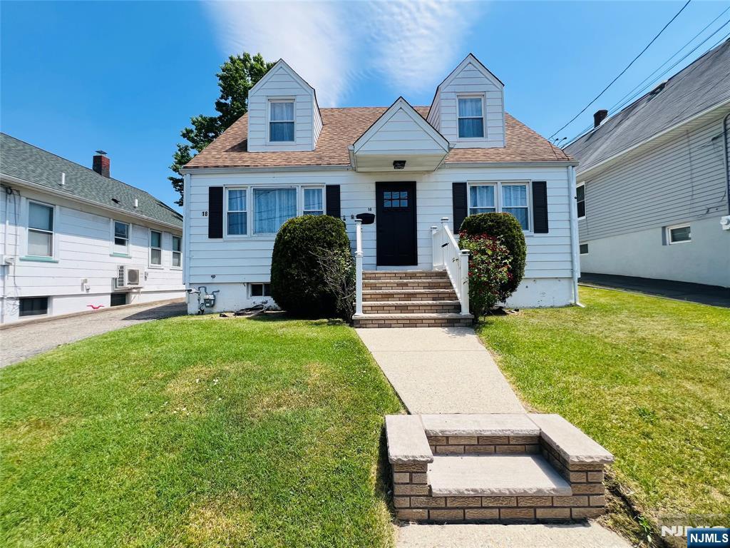 18 Pershing Street Garfield, NJ 07026 - Photo 1 of 16 a front view of a house with garden