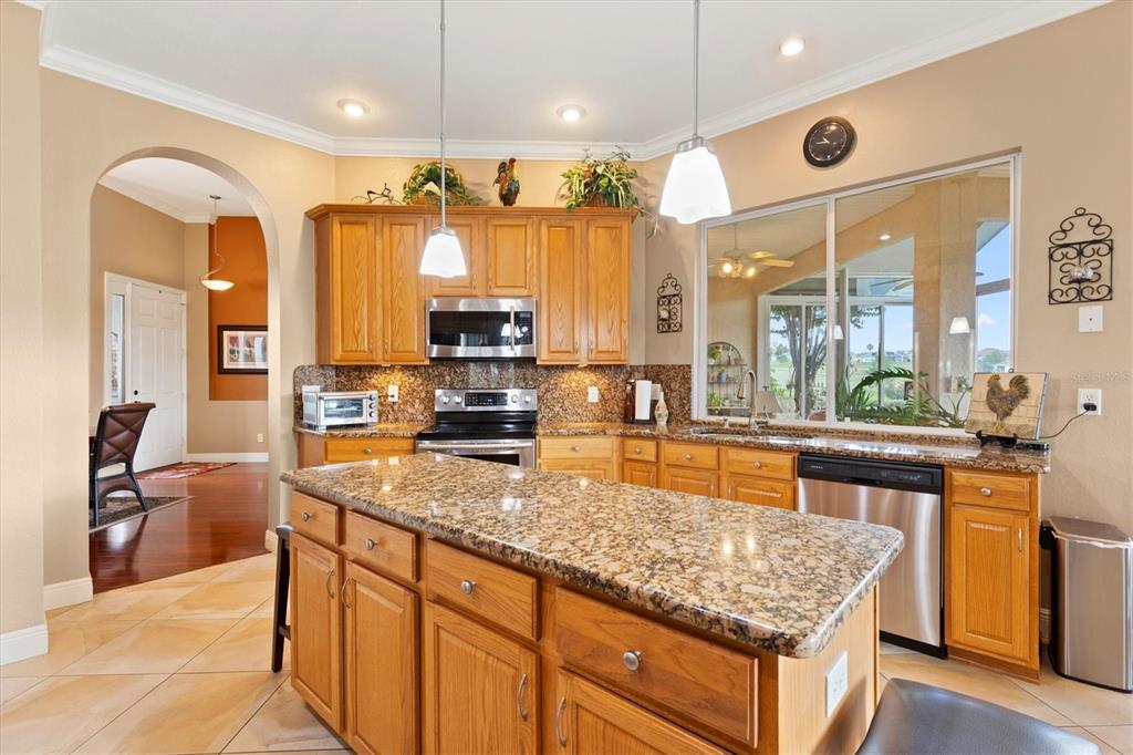 11839 Southeast 173rd Ln Road Summerfield, FL 34491 - Photo 14 of 49 a kitchen with stainless steel appliances granite countertop a sink a stove and a refrigerator