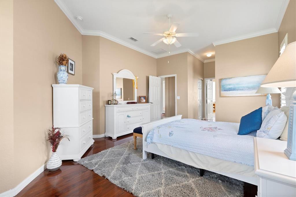 11839 Southeast 173rd Ln Road Summerfield, FL 34491 - Photo 23 of 49 a spacious bedroom with a bed and a chandelier