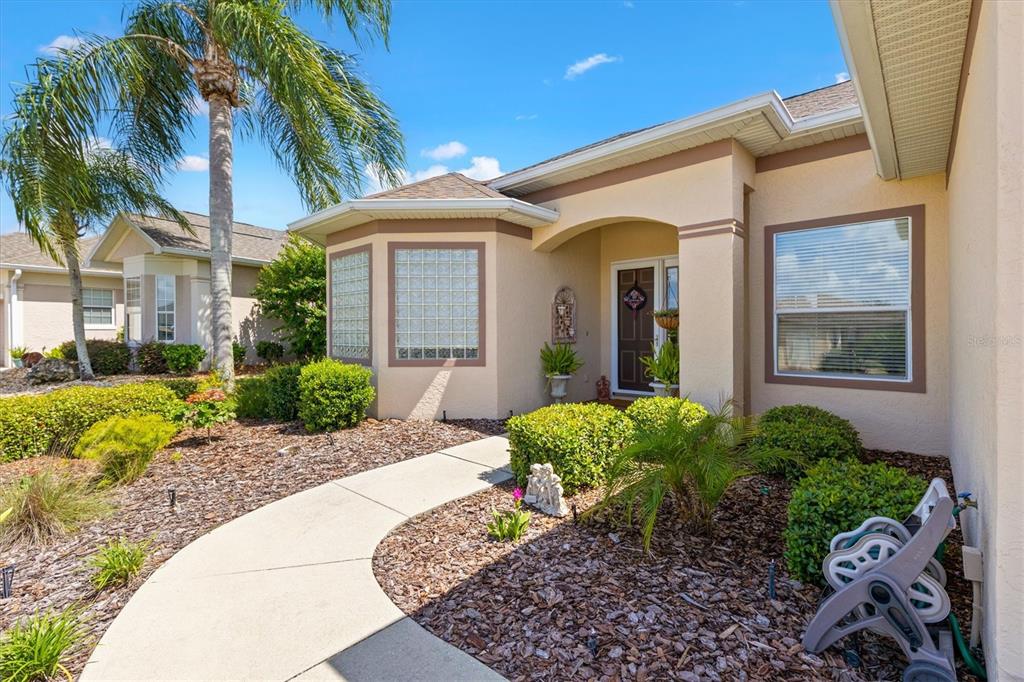 11839 Southeast 173rd Ln Road Summerfield, FL 34491 - Photo 7 of 49 a view of a house with a small yard plants and palm trees