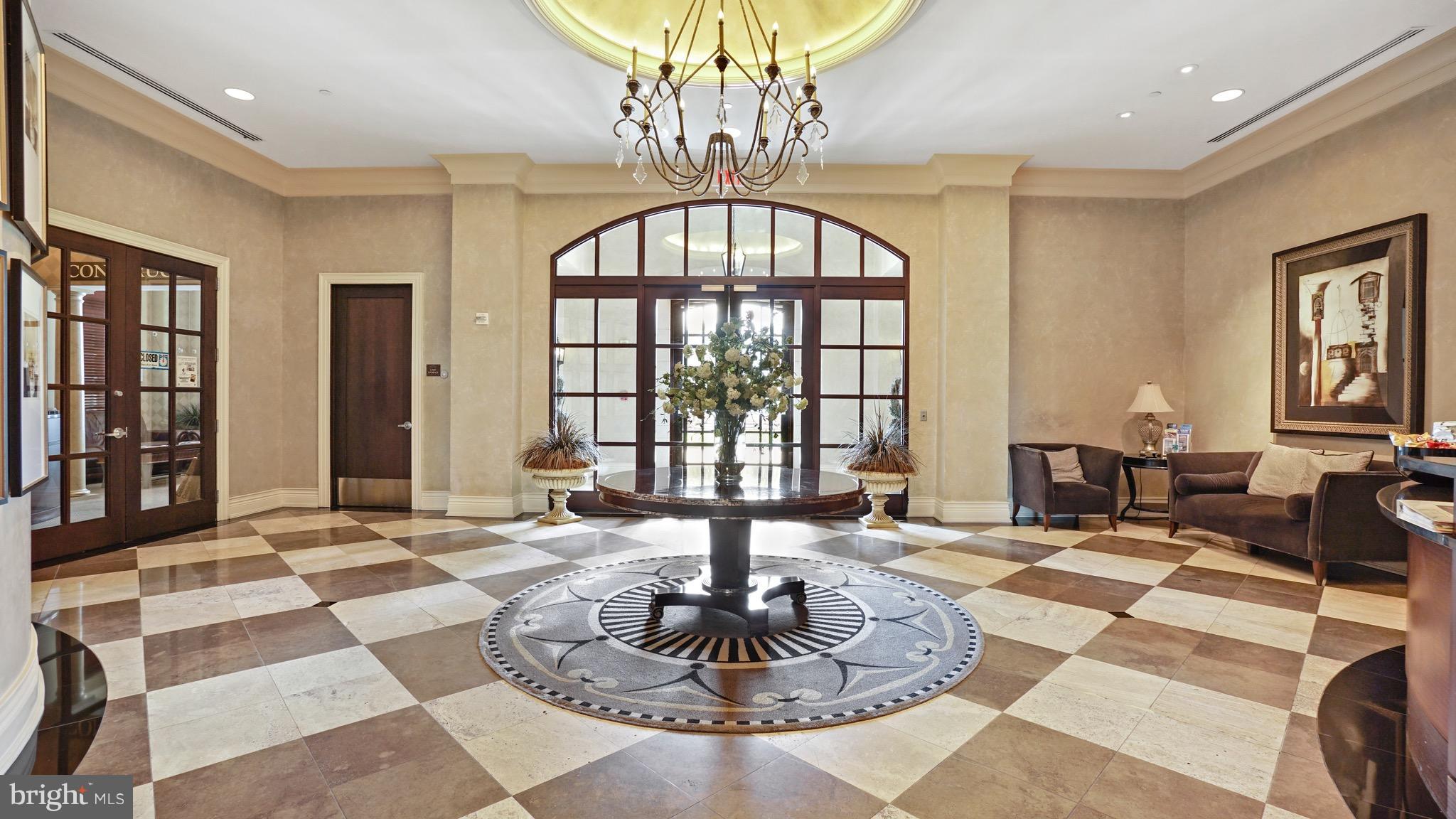 11710 Old Georgetown Road, Unit 1026 Rockville, MD 20852 - Photo 4 of 22 a living room with large windows and a chandelier