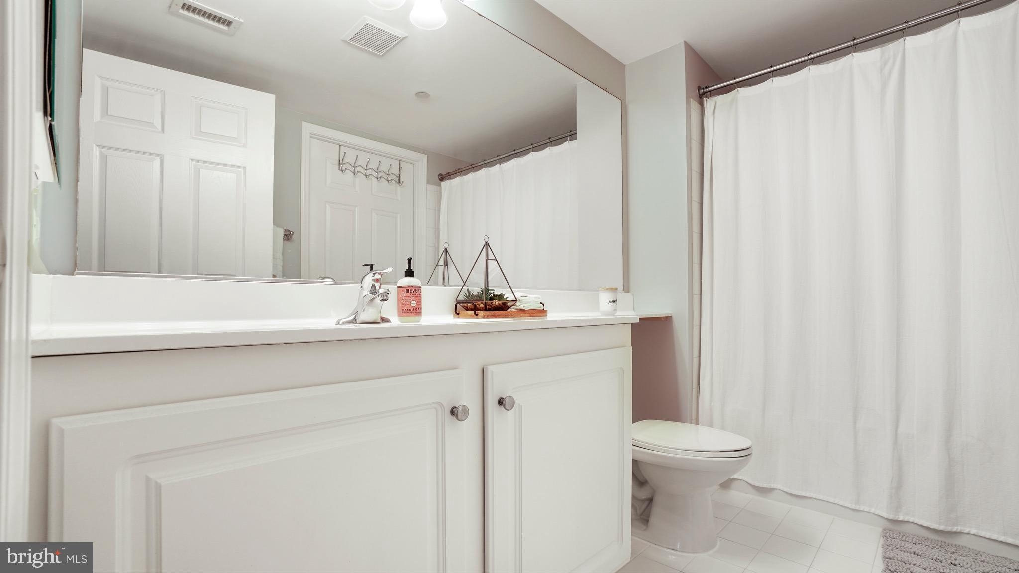 11710 Old Georgetown Road, Unit 1026 Rockville, MD 20852 - Photo 10 of 22 a bathroom with a sink a toilet and a mirror