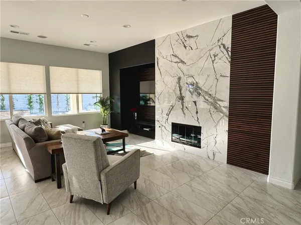 a living room with furniture a fireplace and a large window
