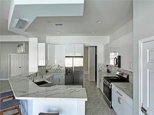 a kitchen with stainless steel appliances granite countertop a sink stove and refrigerator