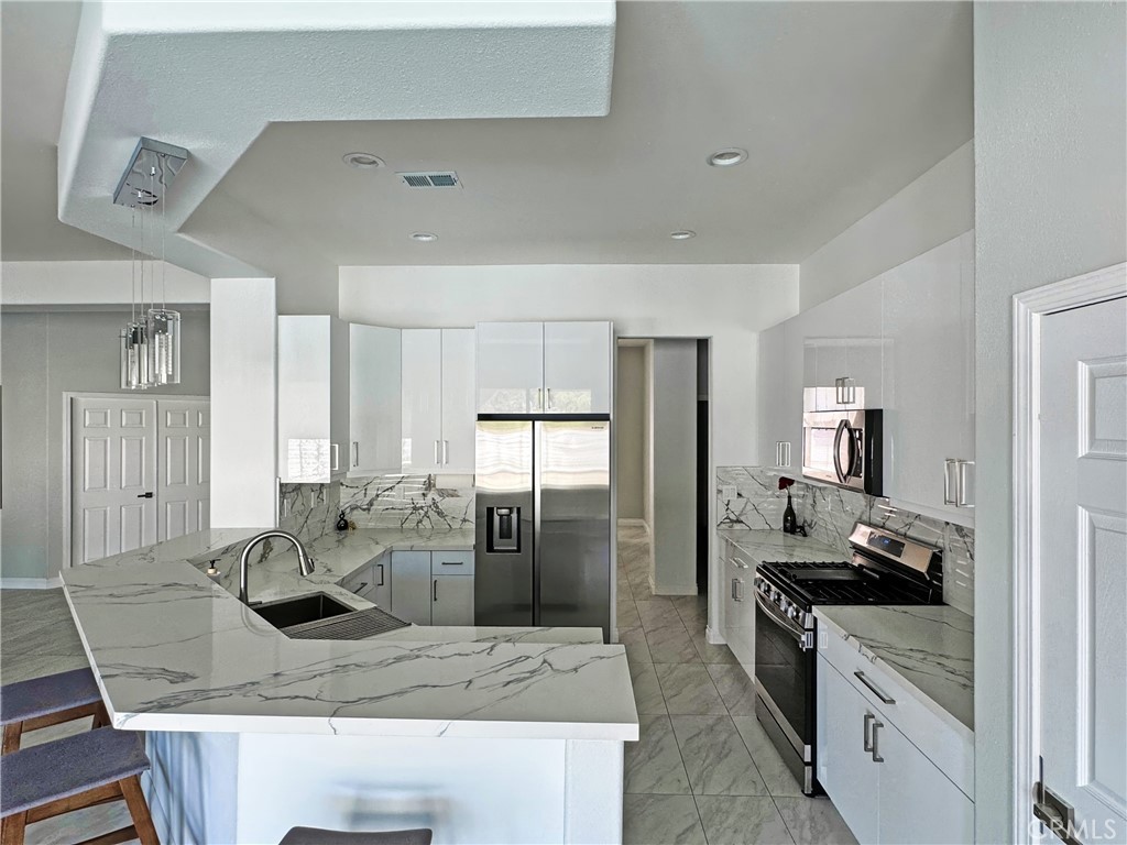 43244 Freesia Place Indio, CA 92201 - Photo 3 of 17 a kitchen with stainless steel appliances granite countertop a sink stove and refrigerator