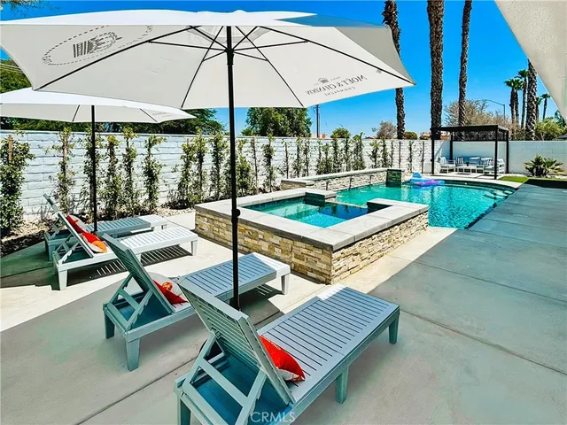 a roof deck with table and chairs under an umbrella
