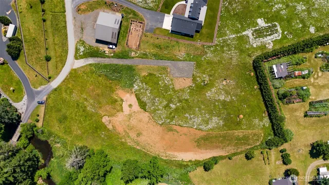 an aerial view of a house with a yard and lake view