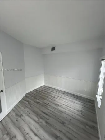 a view of an empty room and wooden floor