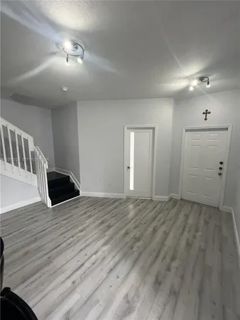 a view of empty room with wooden floor