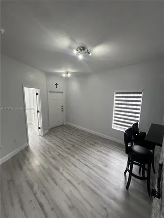an empty room with wooden floor and a window