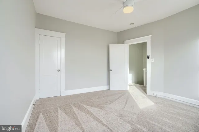 an empty room with windows and ceiling fan